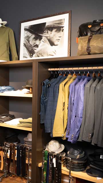 Jacken in einer Garderobe und Gürten davor im Specimen Style Co. Ladenlokal